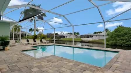 Pool terrace with an open view of the canal and palm trees.