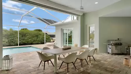 Covered terrace with a large dining table and barbecue.