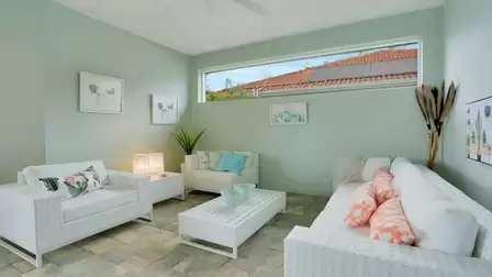 Cozy lounge area with white wicker furniture, pastel-colored accents, and a modern design.
