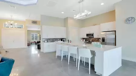 Open-concept kitchen with a large island and view of the elegant entrance area.