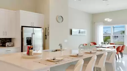 Tastefully decorated dining area with an adjacent modern kitchen and outdoor view.