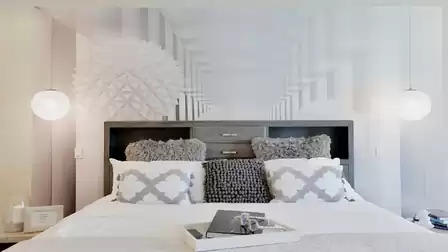 Close-up of the king-size bed in the master bedroom with modern decorative pillows.
