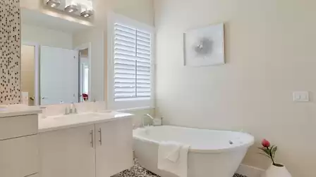 Elegant bathroom with a freestanding bathtub and large mirror.