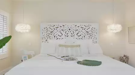 Guest suite: Luxurious bedroom with ornate white headboard and warm lighting.