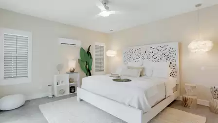 Guest suite: Elegant bedroom with a white king-size bed, decorative headboard, and soft lighting.