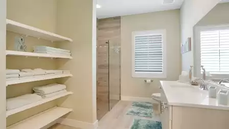 Guest suite: Stylish bathroom with an open shower, white bathroom furniture, and soft towels.