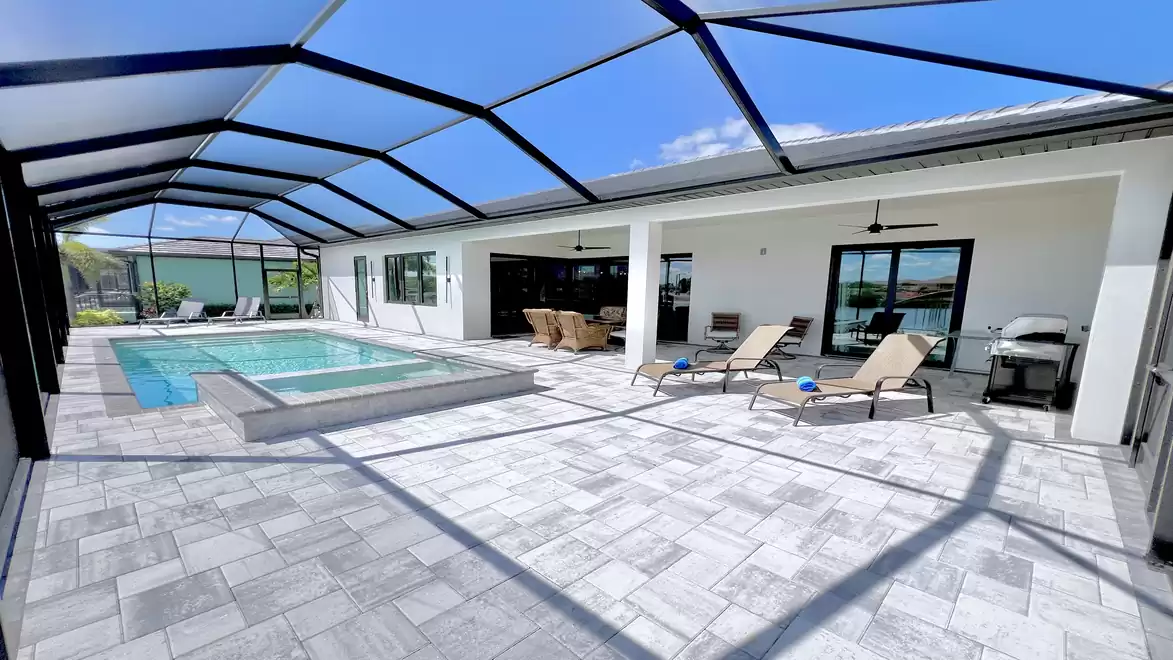 Screened outdoor lounge area with modern pool, spa, and sun loungers at Villa Aldiana in Cape Coral Wenn du bereit bist, sende mir gern das nächste Bild.