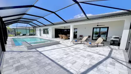 Screened outdoor lounge area with modern pool, spa, and sun loungers at Villa Aldiana in Cape Coral Wenn du bereit bist, sende mir gern das nächste Bild.