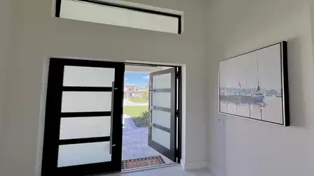 Modern entrance area featuring a frosted glass door and nautical wall art.