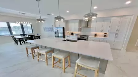 Fully equipped kitchen with large island, modern appliances, and cozy dining area by the window.
