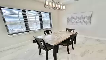 Dining area with marble tabletop and large window - a stylish spot with waterfront view.