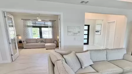 Bright den with sleeper sofa, large windows, and stylish curtains - perfect as an extra bedroom or private retreat.