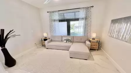 Cozy sleeper sofa with ottoman in a bright den, accented by modern lamps and tasteful wall art.