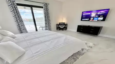 Bright bedroom with king-size bed, smart TV, and desk area - ideal for relaxing evenings or productive work with a view.