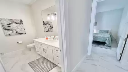 Modern bathroom between Guest Rooms 2 and 3 with shower, toilet, sink, and ample storage.