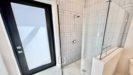 Modern walk-in shower next to the terrace access - both stylish and convenient.