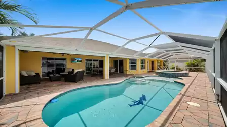 Covered terrace area with cozy lounge, TV and dining table - relaxed outdoor lifestyle under the blue sky.