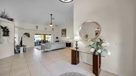 Welcoming entrance area with a view into the bright living room, modern decor, and large glass doors opening to the terrace.