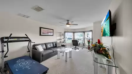 Office and leisure room with desk, sofa, treadmill, and TV – ideal for working, reading, or staying fit while on vacation.