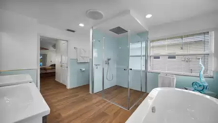 The master bathroom, decorated entirely in light blue, white and lots of glass