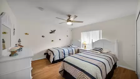 Bedroom with two twin beds in a coastal style, decorated with fish and beach-themed accents.