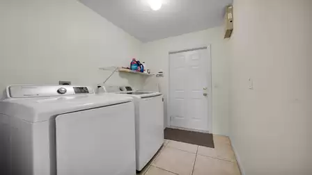 Utility room with washing machine, dryer and access to the garage.
