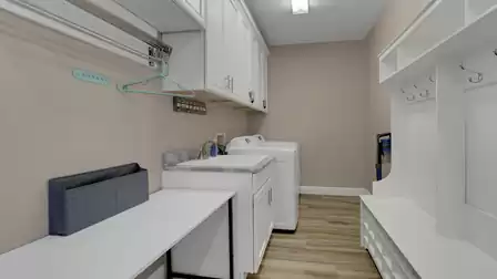 Utility room with washer, dryer, sink and plenty of storage space