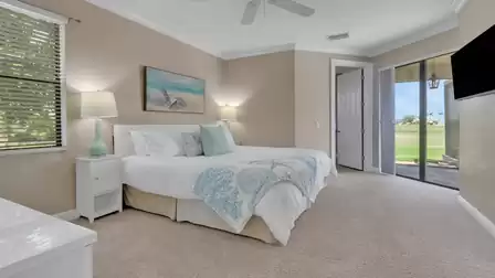 Bright bedroom furnished in subtle colors with king-size bed, TV and direct access to the terrace