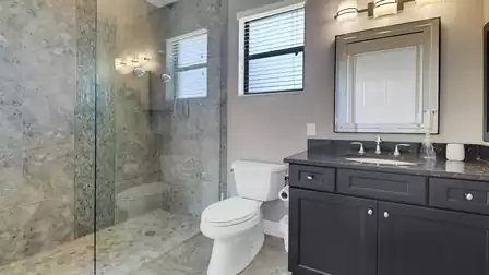 Modern bathroom with large glazed shower, sink and WC