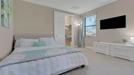 View of the queen-size bed, TV and walk-in closet