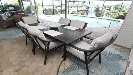 Cozy dining area with pool and canal view - ideal for outdoor meals.