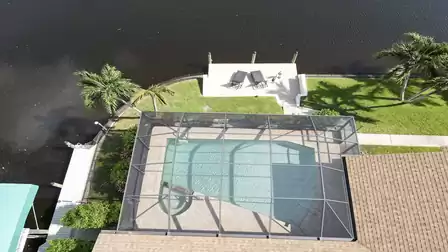 Pool, palm trees and private dock - the aerial view reveals the tropical setting right on the water.