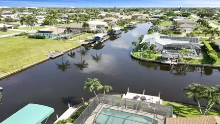 View along the canal with direct Gulf access - classic Cape Coral with palms, docks, and water all around.