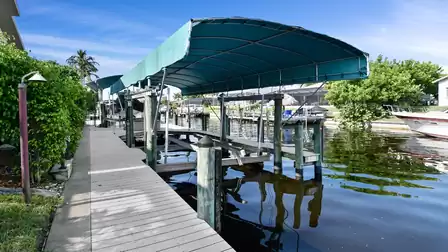 Spacious dock with covered boat lift. Palm trees and a calm canal create the true Florida vibe.