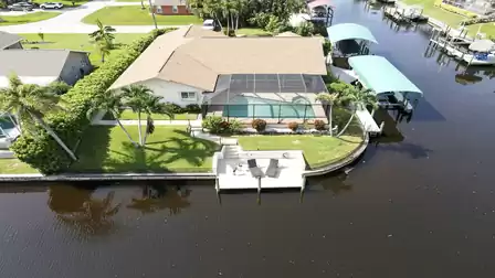 Spacious corner lot with pool, palm trees and sun deck right by the water. Vacation starts right here.