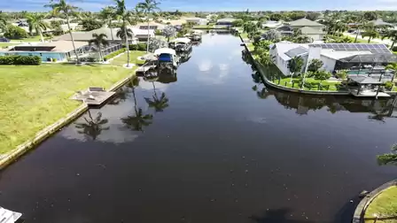 Wide canal lined with palm trees and direct access to the Gulf. Pure sunshine and serenity in Cape Coral.