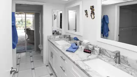 All-white bathroom with blue decorations, 2 sinks, shower, WC and access to the terrace