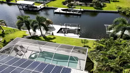View of the pool, palm trees and boat lift from above - ideal for fishing or a spontaneous boat trip