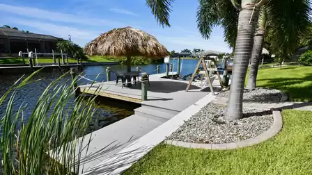 Tiki hut with table and chairs by the canal - perfect for a cool drink in the afternoon or a relaxed chat by the water.
