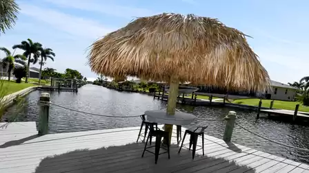 Tiki hut with bar stools by the canal – a tropical spot for a sundowner, a cool afternoon drink or lively conversations outdoors.