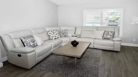 Modern sofa in light tones with decorative cushions and table - perfect for relaxing TV evenings