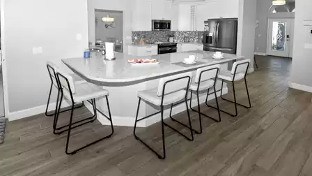 Bright kitchen with large breakfast bar in modern design and high-quality appliances.