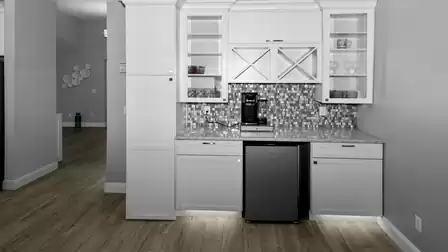 Elegant coffee bar with plenty of storage space, glass cabinets and fridge - ideal for that first coffee in the morning