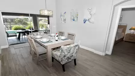 Stylish dining area with comfortable chairs and a direct view of the pool and terrace.