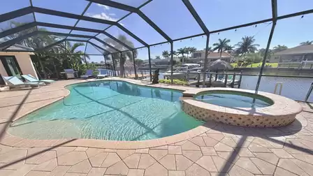 Large pool with whirlpool on the terrace in the screened patio overlooking the canal.