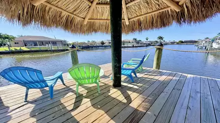 Tiki hut with comfortable seating at the private dock, offering open canal views in a relaxed tropical setting.