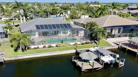 Aerial view of Villa Preziosa with pool, screened patio, landscaped garden and private boat dock on the canal.