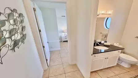 Hallway view with bathroom and walk-through to the adjoining bedroom.