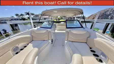View inside a comfortable motorboat with seating and sun canopy, docked at a private waterfront pier.