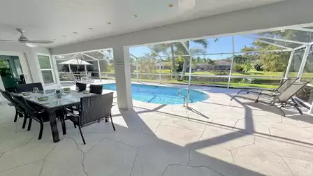 Open lanai area in the screen with dining table and view over the pool